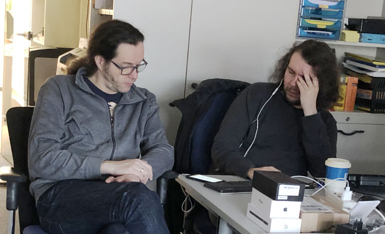 Testsituation: blinder Nutzer und sein sehender Assistent betrachten ein Mobiltelefon