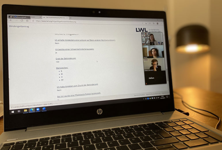 Laptop-Bildschirm mit Ansicht des Online-Blindengeldantrags und kleinen Bildern der Test-Teilnehmenden.