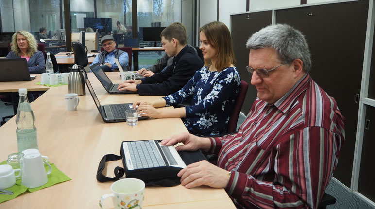 5 Personen an Laptops, im Vordergrund eines mit Braillezeile